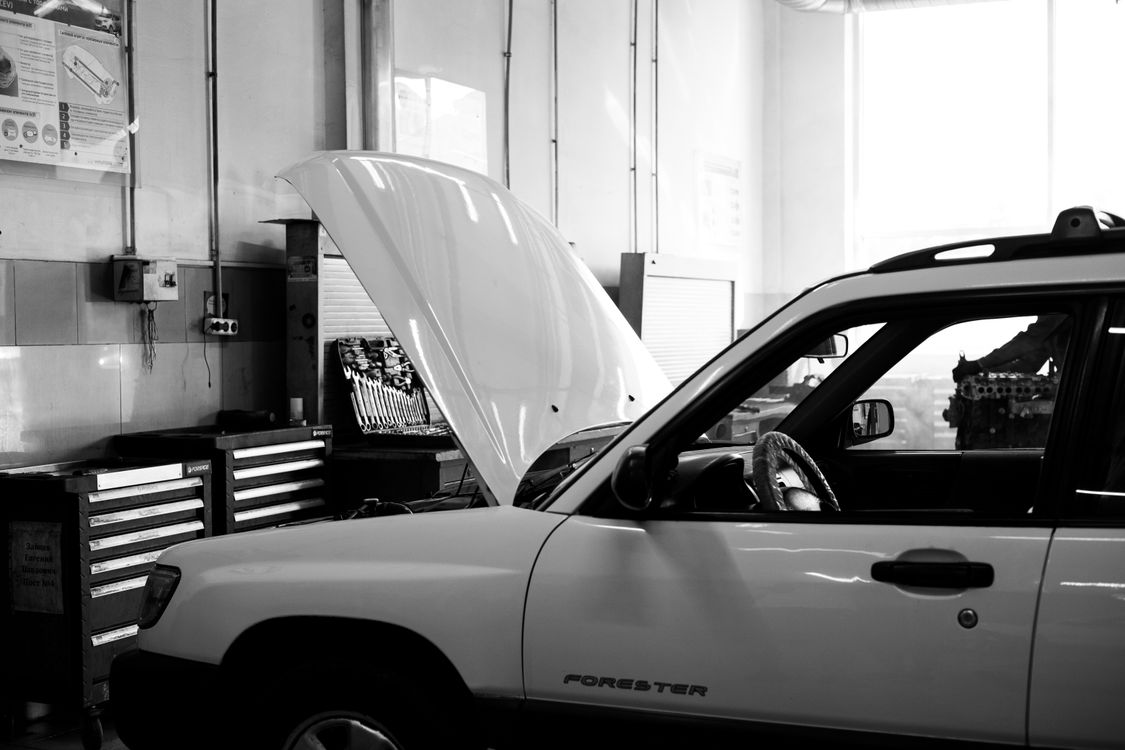 Car in workshop with hood open